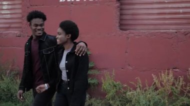 Mutlu Afro-Amerikalı kadın ve erkek garaj kafesinin önünden geçiyor.