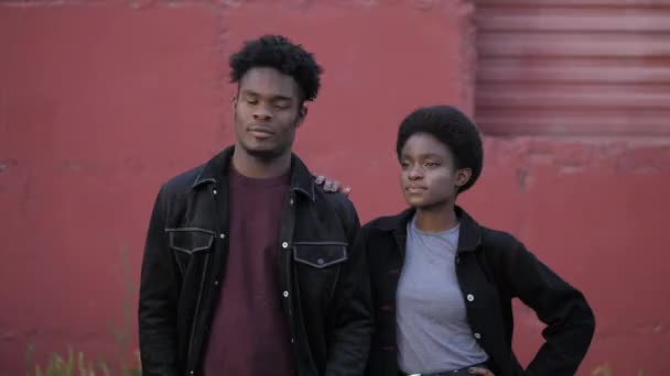 African-American woman looks at boyfriend near red garage — Stock Video