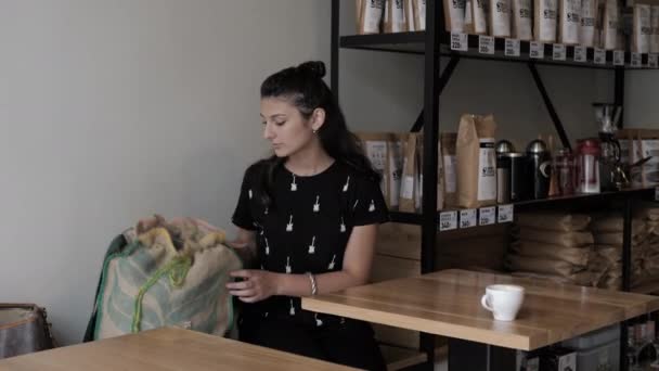 Brunette woman takes large sack going out of neat cafe — Stock Video