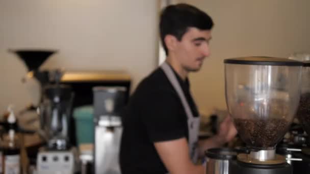 A szürke kötényes csapos kávéfőzővel dolgozik a kávézóban — Stock videók