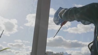 Pencereye güneş ve bulutlar çizen kız silueti
