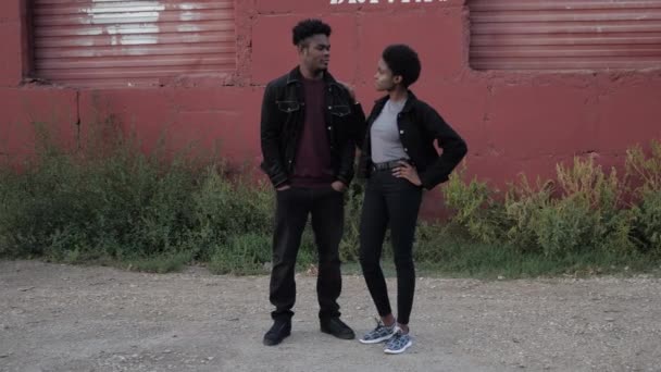 Αφροαμερικανό ζευγάρι με denim ρούχα κοντά στο κόκκινο γκαράζ — Αρχείο Βίντεο