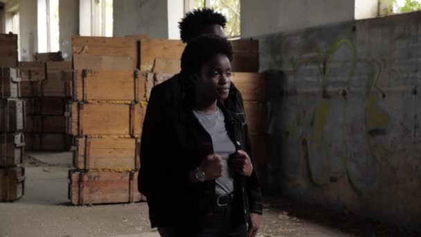 Cheerful African-American couple in denim in old storehouse — Stock Video