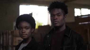 Erkek arkadaşı eski depoda poz veren Afro-Amerikalı bir kadın.