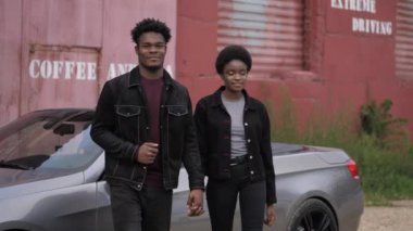 Afro-Amerikalı erkek ve genç kadın Cabriolet 'e karşı yürüyorlar