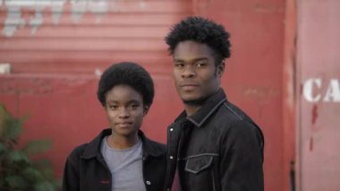 Eski kırmızı garajın yakınında erkek arkadaşı olan Afro-Amerikalı bir kadın.