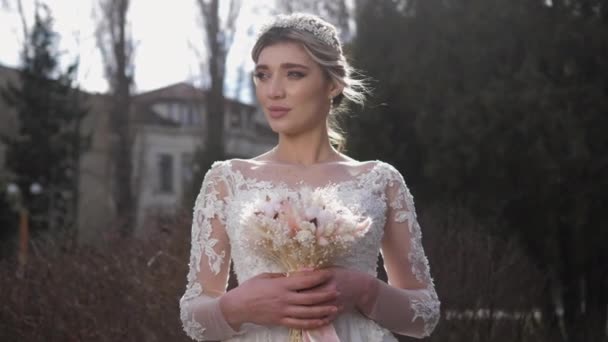 Cheerful bride in gorgeous dress holds gentle bouquet — Stock Video