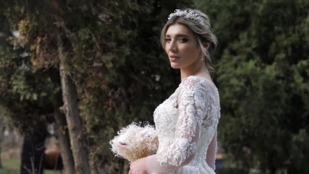 Wanita ceria dalam gaun pengantin dengan buket lembut dan tiara — Stok Video