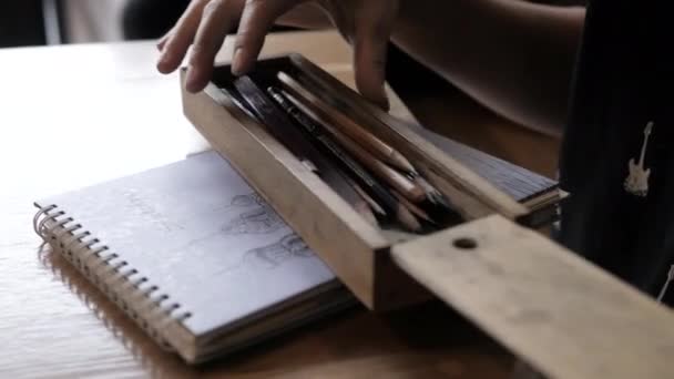 Femme ferme boîte à crayons sur ordinateur portable avec croquis à la table — Video