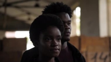 Afro-Amerikalı kız, yakışıklı bir erkekle kameraya poz veriyor.