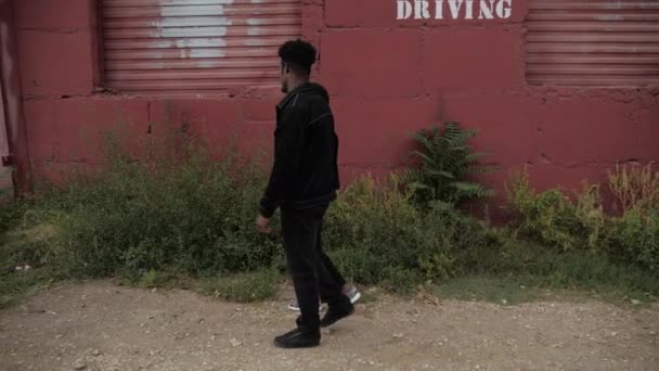 Hombre afroamericano con amigo caminar más allá de viejo edificio rojo — Vídeos de Stock