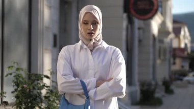 Tişört ve tesettürlü profesyonel model düz duruyor.