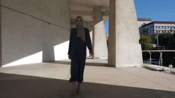 Dame in langem Kleid und Hijab läuft über gepflasterten Gehweg — Stockvideo