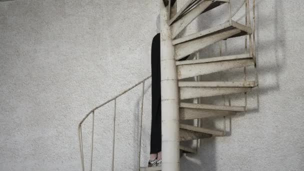 Mladá žena v dlouhých šatech a hidžáb se usmívá na schodišti — Stock video