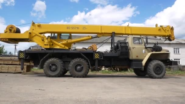 Truck crane with folded arm stands in woodworking plant yard — Stock Video