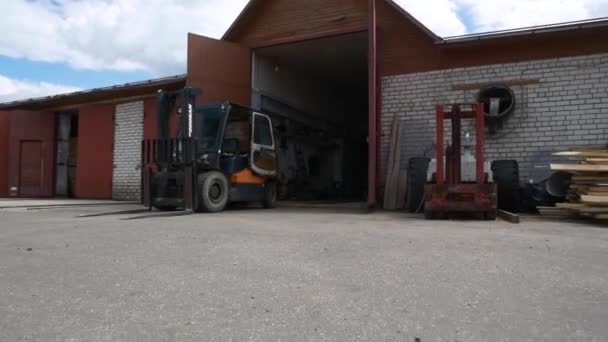 Villástargonca áll közelében nyitott kapu tégla raktár — Stock videók