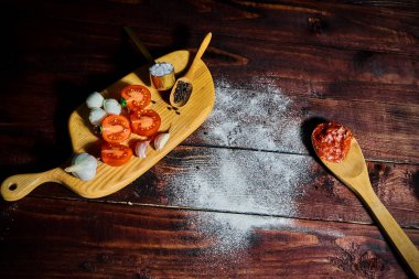 Ahşap arka plan üzerinde domates, zeytin yağı, yeşil fesleğen ve Mozzarella ile pizza hamur