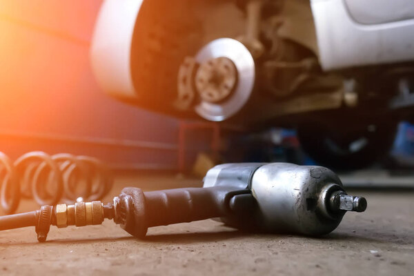 Auto mechanic man with electric screwdriver changing tire outside. Car service. Hands replace tires on wheels. Tire installation concept.