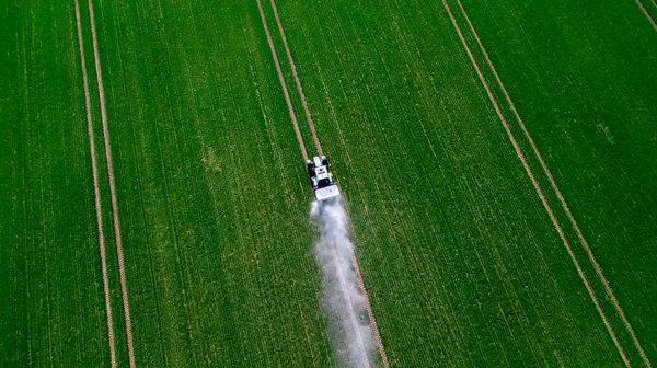 Luftaufnahme des Traktors, der die Chemikalien auf der großen grünen Wiese versprüht — Stockfoto