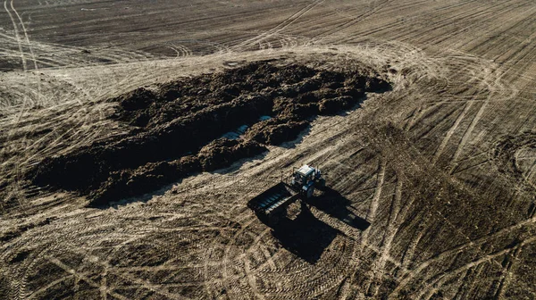 Hnojiva na poli. Traktor u hromady hnoje. Letecký průzkum — Stock fotografie