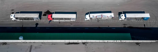 Logistics center aerial view from above. Trucks on loading