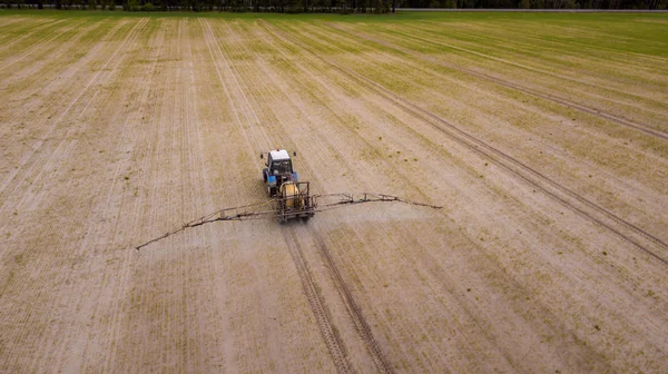 Veduta aerea del trattore agricolo aratura e spruzzatura sul campo — Foto Stock