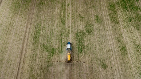 Vista aérea de lavoura trator agrícola e pulverização no campo — Fotografia de Stock
