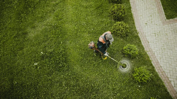 Sekačka na trávu poskvrní trávník pohledem shora — Stock fotografie