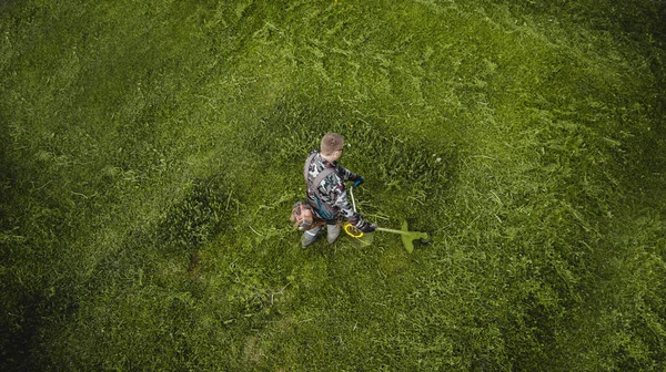 芝刈り機の男は芝生を上から見る — ストック写真