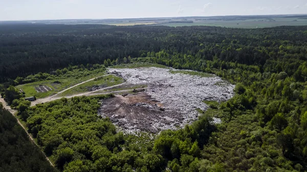 landfill removal of unsorted debris in the middle of the forest. Aerial photography with drone