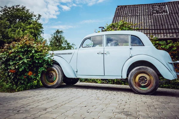 Très vieille voiture sur fond de fleurs — Photo