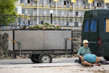  Odessa, Ukrayna-Haziran 2019: kamuflajın içinde adam karavanda, ve adamın yanında bir davul ile oturur