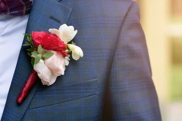 Boutonniere novio primer plano sobre un fondo azul — Foto de Stock