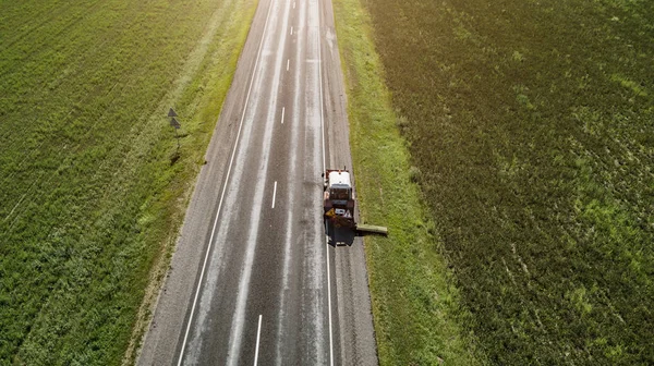 Traktor mäht den Straßenrand entlang der Straße Luftaufnahme — Stockfoto