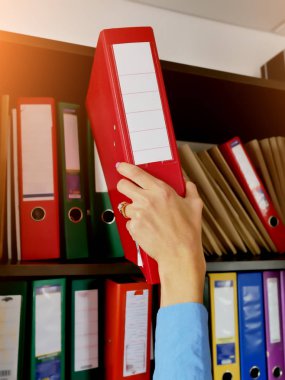 arşivdeki kız raf yakın çekim belgeleri ile bir klasör koyar