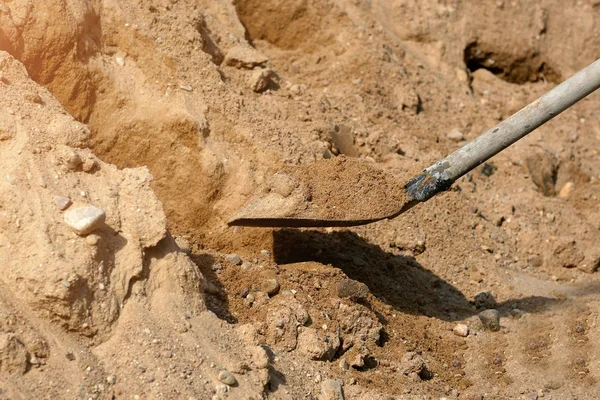 Лопата на фоне груды гравия крупным планом — стоковое фото