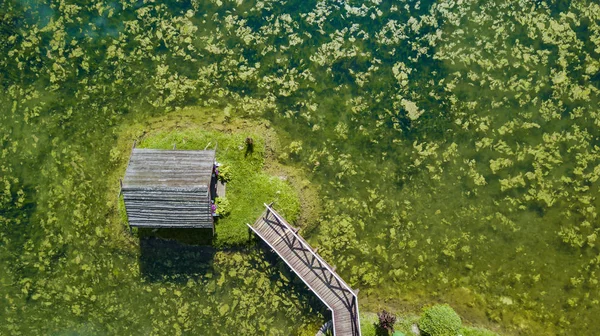 Malý domek na ostrově uprostřed leteckého pohledu na jezero — Stock fotografie