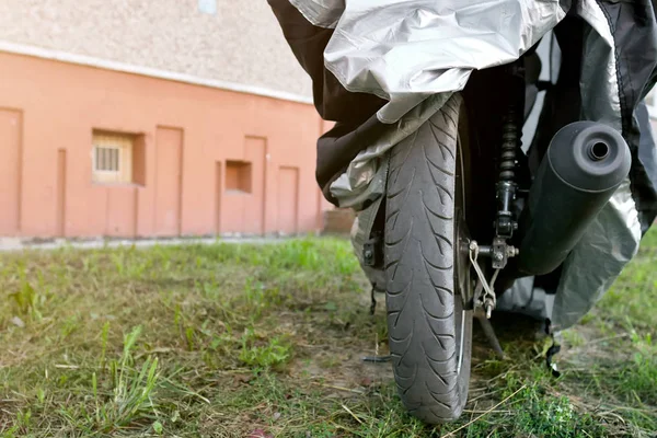 motorcycle under protective cover on the street