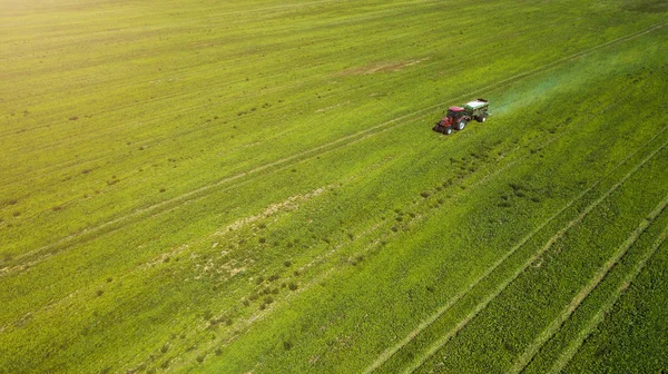 Zemědělský traktor se pohybuje po celé oblasti, přičemž rozmetání minerálních hnojiv — Stock fotografie
