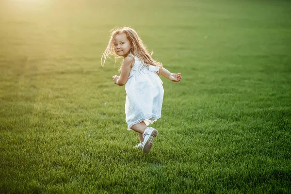 Une fille en robe blanche court à la rencontre du soleil . — Photo