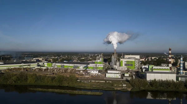 panorama of the industrial enterprise, the smoke from the pipes against the blue sky