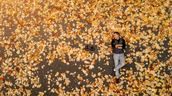 Fotograf na podzimním pozadí leží na zemi fotografie shora — Stock fotografie