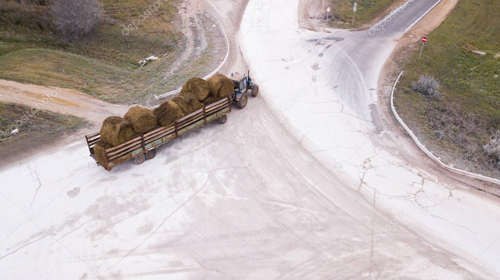 the tractor carries the bales of straw
