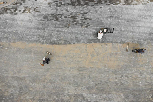 主人は石を敷く 歩道の修理 道路労働者の空中ビュー — ストック写真