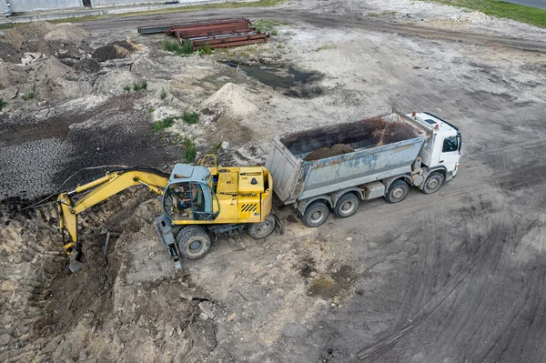 掘削機は砂をトラックに積み込み — ストック写真