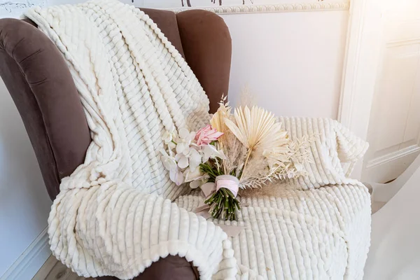 the bouquet is lying on a white blanket in a chair.