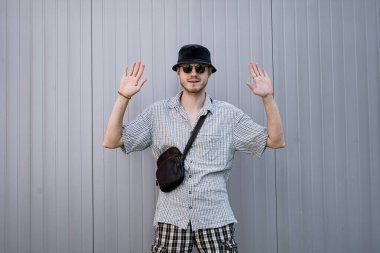 Şapkalı bir hippinin portresi elleri havada duruyor..