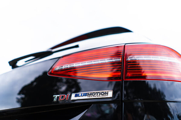 Надпись TDI на кузове автомобиля крупным планом.