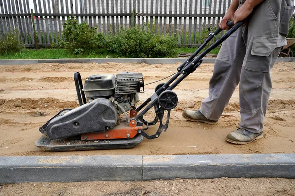 Worker Rams Ground Vibrating Machine Side View — Stock Photo, Image
