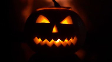 Şöminenin yanında ürkütücü Cadılar Bayramı balkabağı. Arka planda ateş.